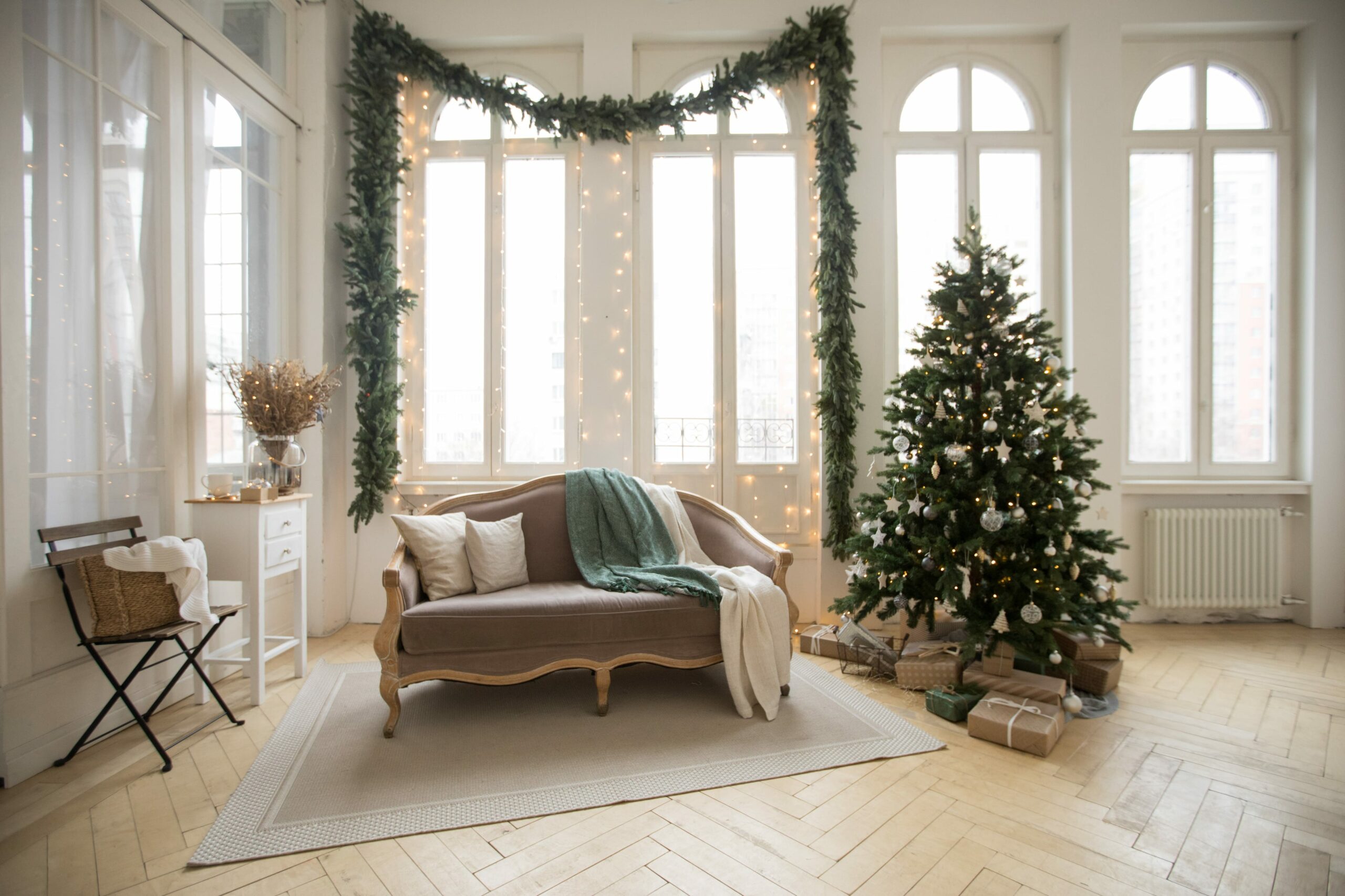 房间有浅色木地板，圣诞树和沙发
